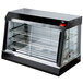A black and silver Vollrath countertop hot food display case with glass doors.