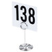 An American Metalcraft chrome swirl base table card holder with a number in it.