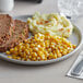 A plate of meatloaf with mashed potatoes and Regal Whole Kernel Sweet Corn on the side.