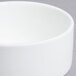 An Arcoroc white porcelain stackable bouillon cup with a white rim.