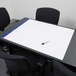 An Ampad white paper flip chart on a table with chairs.