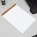 A TOPS white legal pad with wide ruled paper on a desk.