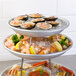 A Choice 4" Chrome Plated Steel Display Stand holding a tray of seafood on ice with lemons and sauce.