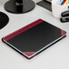A black and red Boorum & Pease accounting notebook on a white desk.