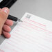 A hand using a black pen to fill out a CMS-1500 health insurance claim form.