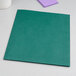 A green Oxford pocket folder on a white surface.