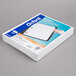 A white box with blue and orange text on the side and a white paper on top.