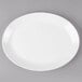 An ivory melamine oval platter with a white rim on a gray surface.