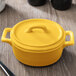 The yellow porcelain lid for a Bon Chef oval casserole dish.
