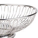An American Metalcraft stainless steel oval basket with a circular rim on a table.
