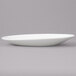 A white porcelain saucer on a gray surface.