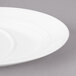 A close-up of a white Bon Chef porcelain saucer with a slanted oval shape.