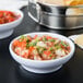 A close-up of a white Thunder Group melamine salsa bowl filled with salsa.