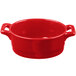 A red porcelain Bon Chef oval casserole dish with handles.
