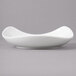 A close-up of a white Bon Chef porcelain salad bowl with a curved edge.