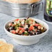 A Thunder Group melamine salsa bowl filled with black bean and corn salsa on a table.