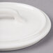 A white porcelain Bon Chef oval lid with a handle.