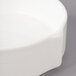 A close up of a white Bon Chef porcelain soup bowl with stacked lines.