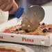 A person using a GI Metal stainless steel double wheel pizza cutter to cut a pizza.