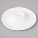 A white Bon Chef porcelain sampler plate with pink concentric circles.