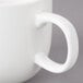A close-up of a white Bon Chef porcelain coffee mug with a handle.