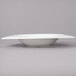 A close up of a white bowl with a curved edge.