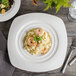 A plate of pasta with shrimp in a Bon Chef white porcelain soft square pasta bowl.