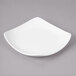 A white square Bon Chef porcelain bread and butter plate with a curved edge.