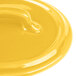 A yellow Bon Chef porcelain cocotte lid with a handle on a yellow plate.