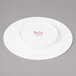 A white Bon Chef bone china bread and butter plate with red writing that says "Bon Chef"