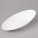 A white oval porcelain bowl with a curved edge.