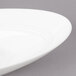 A white Bon Chef slanted oval porcelain bowl with a curved rim.