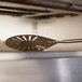 A GI Metal stainless steel round turning perforated pizza peel in an oven.