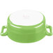 A white porcelain oval cocotte with lime green accents and handles.