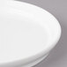 A close-up of a Bon Chef white porcelain plate with a rim.