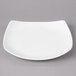 A white Bon Chef porcelain salad plate with a curved edge.