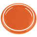The lid for a Bon Chef orange porcelain cocotte on an orange plate with a white rim.
