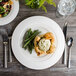 A Bon Chef white porcelain dinner plate with turkey and green beans on a table.