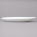 A white Bon Chef porcelain oval plate on a gray surface.