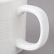 A close-up of a white porcelain Bon Chef coffee mug with stacked lines.