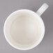 A white Bon Chef porcelain cup with stacked lines and a handle.