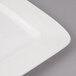 A close-up of a white rectangular porcelain plate with circles on the border.