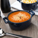 A blue Bon Chef oval cocotte filled with soup and cheese.