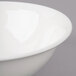 A close-up of a white Bon Chef porcelain bowl with a rim.