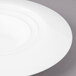 A close-up of a Bon Chef white porcelain bowl with a circular rim.