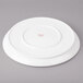 A white Bon Chef porcelain plate with a red rim.