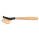 A close up of a Lodge scrub brush with a black handle.