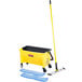 A yellow and black Rubbermaid mop bucket with mop pad and mop handle.