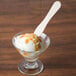 A scoop of ice cream in a bowl with a Royal Paper wooden taster spoon.
