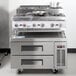 A stainless steel Cooking Performance Group countertop range with two burners and a refrigerated chef base.